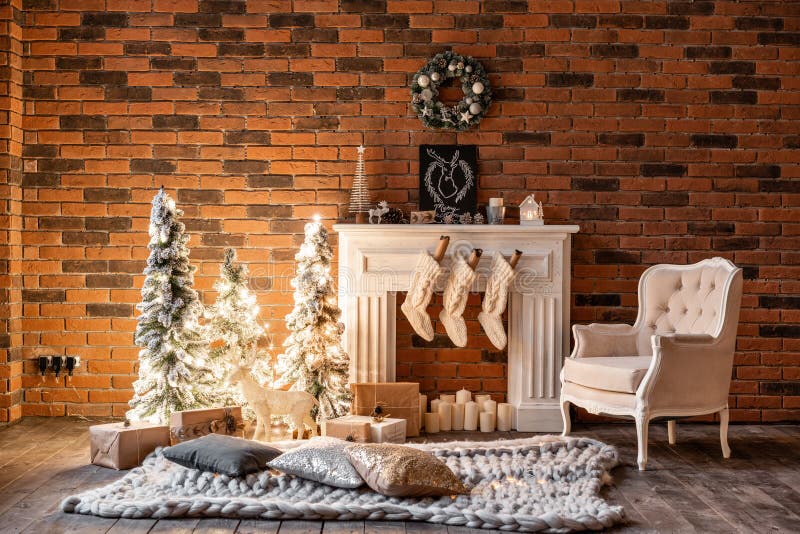 Loft apartments, brick wall with candles and Christmas tree wreath. White wool socks for Santa on the fireplace. Knitted. White wool socks for Santa on the stock image