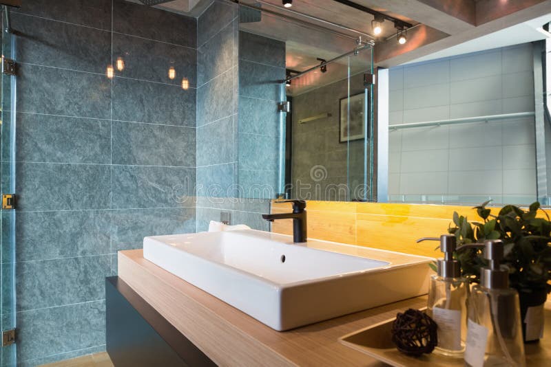 Loft style bathroom. Glass Shower box and white ceramic sink in a loft style bathroom royalty free stock photography