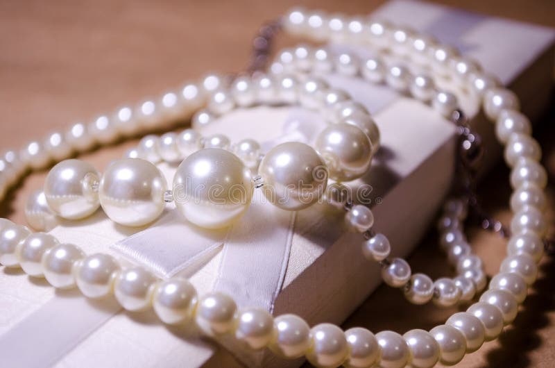 Luxurious decoration. Jewelry made of pearls. Imitation pearl jewelry. Jewelry made of pearls against the background of craft. And a white box for jewelry and royalty free stock images