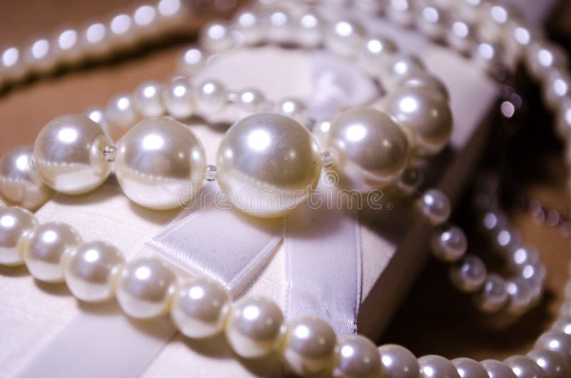 Luxurious decoration. Jewelry made of pearls. Imitation pearl jewelry. Jewelry made of pearls against the background of craft. And a white box for jewelry and stock images