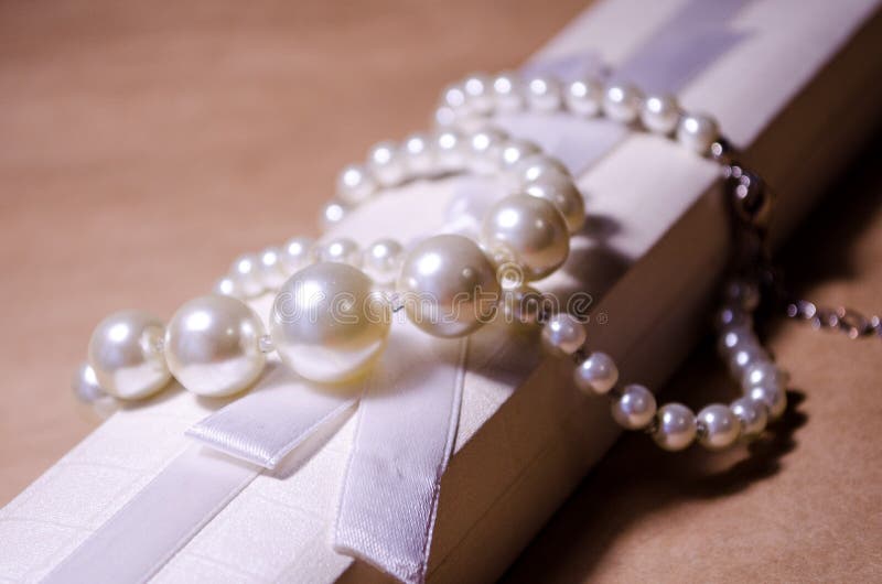 Luxurious decoration. Jewelry made of pearls. Imitation pearl jewelry. Jewelry made of pearls against the background of craft. And a white box for jewelry and stock photos