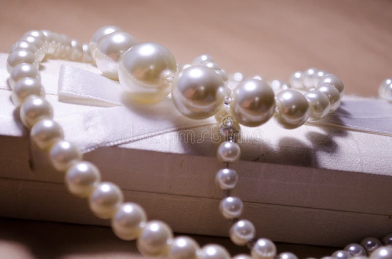 Luxurious decoration. Jewelry made of pearls. Imitation pearl jewelry. Jewelry made of pearls against the background of craft. And a white box for jewelry and royalty free stock images