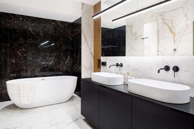 Luxury bathroom with marble tiles. Luxury bathroom with dark and bright marble tiles and big bathtub royalty free stock photos