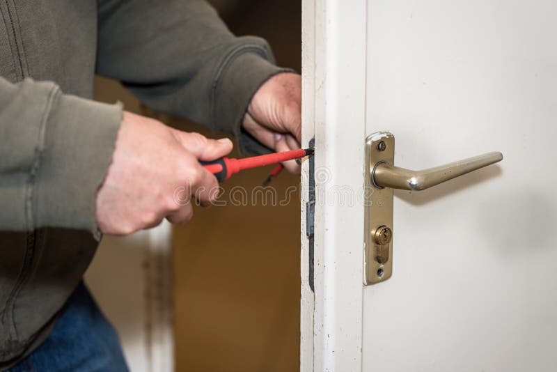 Male handyman worker wood door lock installation or repairing. Male handyman worker at interior wood door lock installation or repairing royalty free stock image