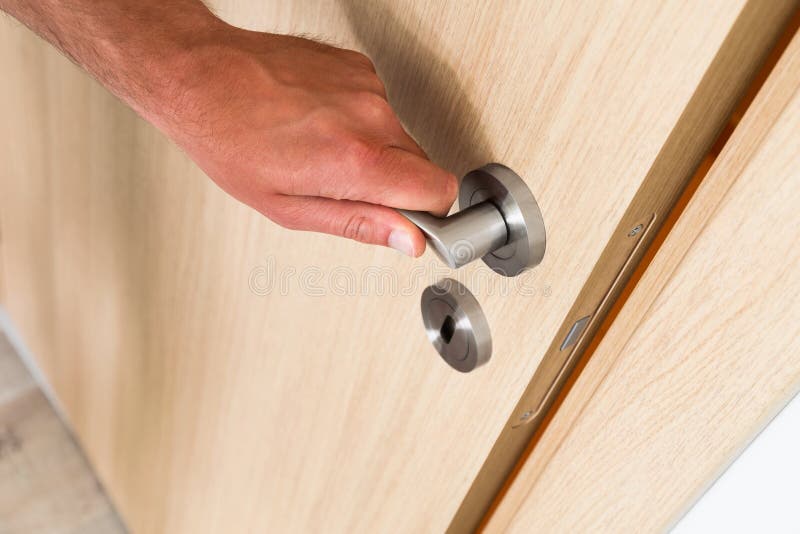 Man closing a light wood interior door stock photos