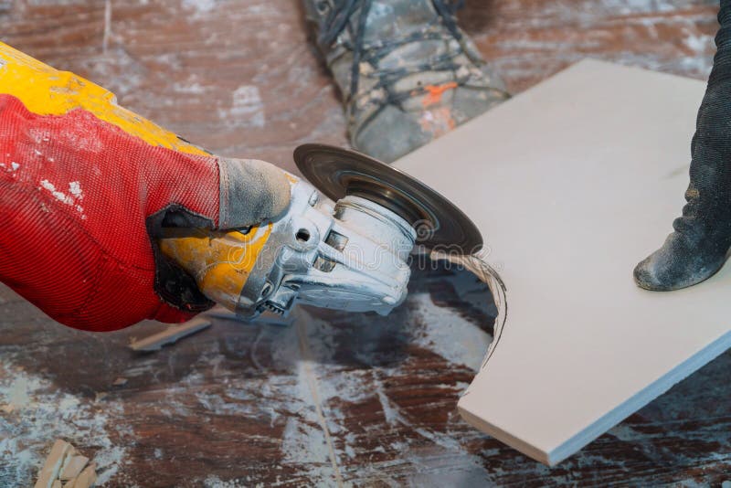 Man worker cutting tile with circular saw. Man cutting tile with using grinder circular saw flooring construction material tool work worker tiler hand ceramic royalty free stock photography