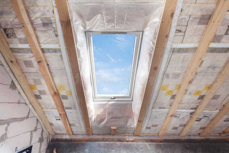 Mansard with environmentally friendly and energy efficient skylight window against blue sky. Room under construction with wooden b royalty free stock photos