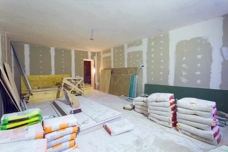 Materials for construction putty packs, sheets of plasterboard or drywall in apartment is under construction. Remodeling, renovation, extension, restoration royalty free stock image