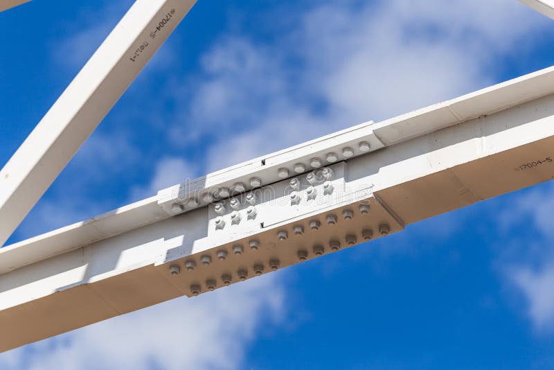 Metal columns with connecting anchor bolts. Building frame against a blue sky stock photo