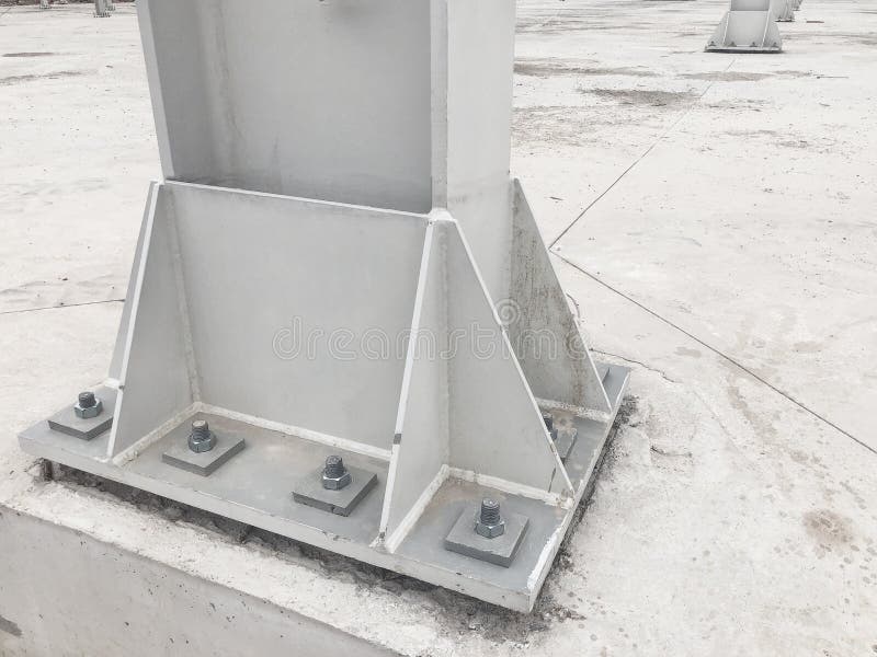 Metal pillar fastened to basement with anchor bolts and nuts. Supporting structures, metal frame of prefabricared building stock photo