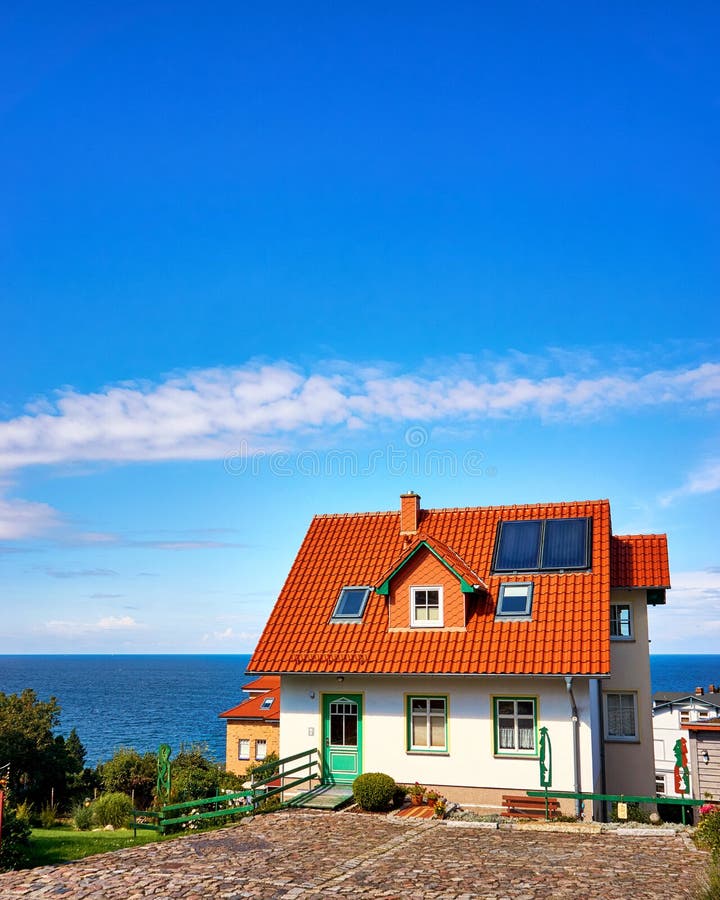 Modern detached house with red roof tiles and solar panels. Living overlooking the Baltic Sea on the island of Rügen. Home, architecture, dwelling, residence royalty free stock image