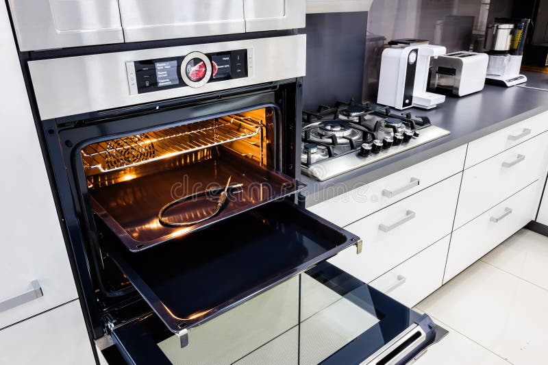 Modern hi-tek kitchen, oven with open door. Modern luxury hi-tek black and white kitchen, clean interior design, focu at oven with open door stock photography