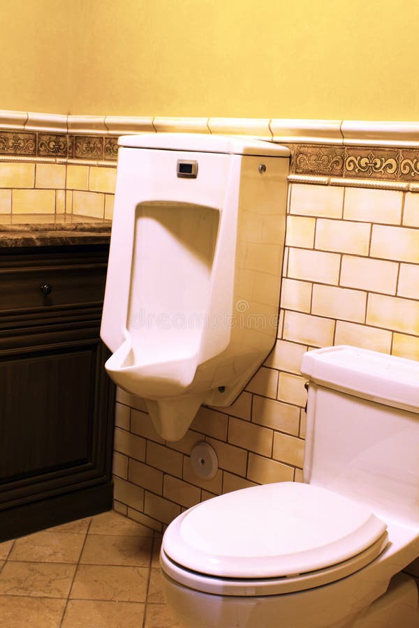 Modern Home Public Bathroom. Urinal and toilet of modern public unisex bathroom stock photography