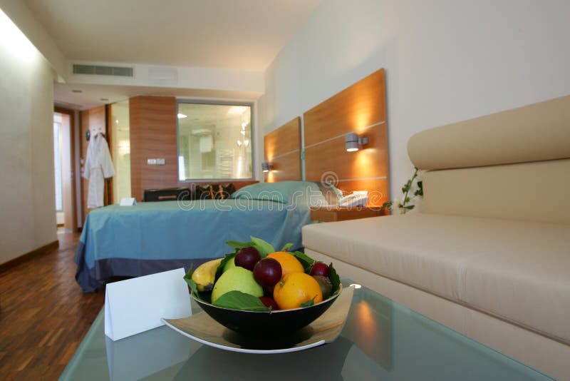 Modern hotel room. Bowl of fruit in a modern hotel room with a blank note for copy text stock photos