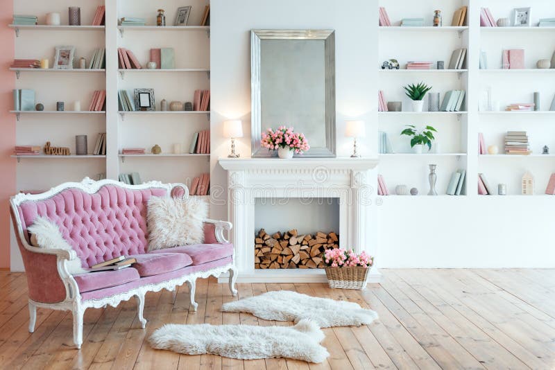 Modern light interior with fireplace, spring flowers and cozy pink sofa.  stock photography