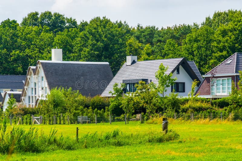 Modern rural houses with a grass pasture, typical dutch houses in Bergen op zoom, The Netherlands stock photos