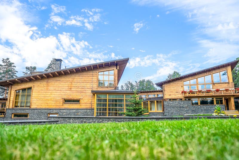 Modern wooden eco-house. With green grass at the sunny summer day stock images