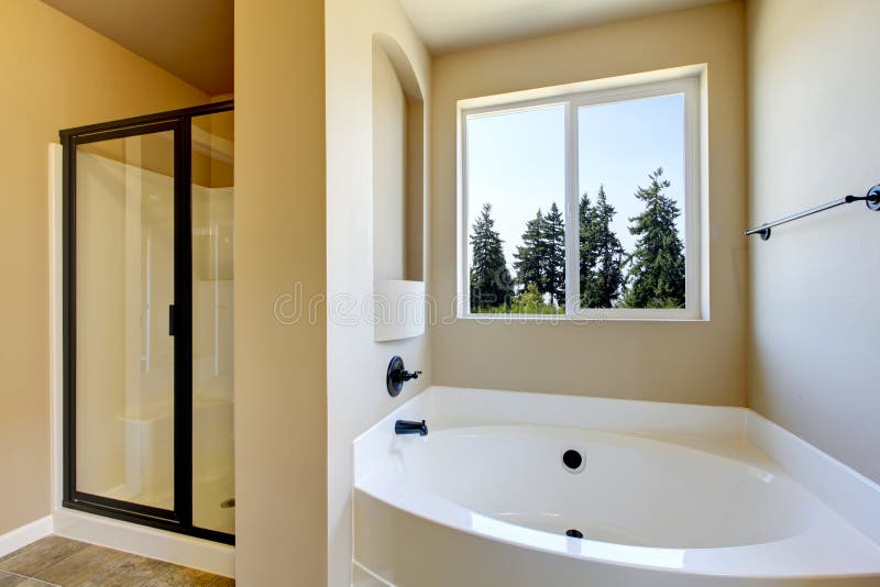 New home bathroom with shower and bath. New home bathroom interior with shower and bath combination, wood cabinet and toilet royalty free stock photo