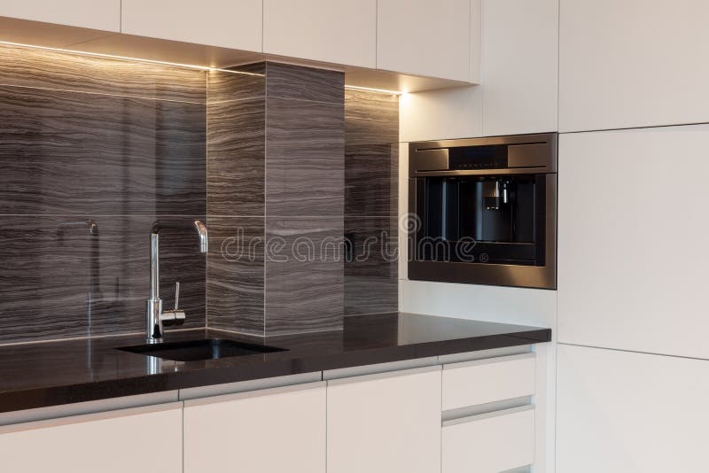 New modern kitchen with built in oven and chrome water tap. LED worktop illumination. New modern kitchen with built in oven and chrome water tap. LED worktop stock image