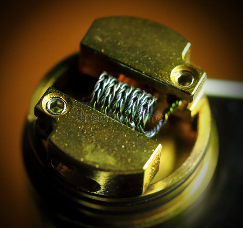 Nichrome Coil, nichrome wire vape on a dripper gold. vaporizer. E-cig, e-cigarettes stock image