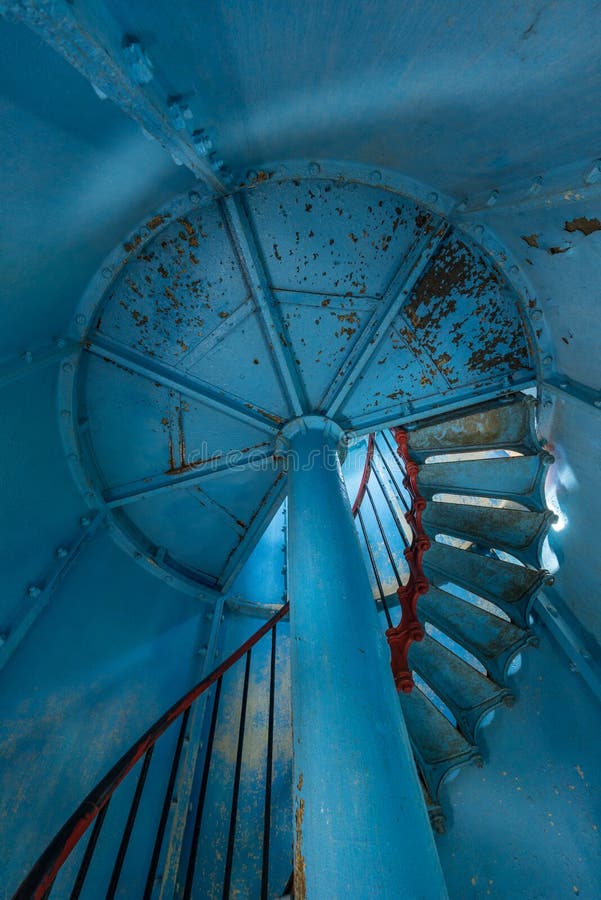 Old lighthouse on the inside. Red iron spiral stairs, round window and blue wall. Kihnu, small island in Estonia. Europe stock images