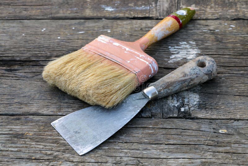 Old Paintbrush and Spatula. Old paintbrush and metal spatula on rustic wooden table stock photos