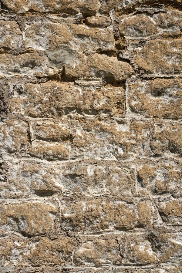 Old weathered exterior stone wall construction full frame background. An old previously painted weathered stone wall needs repairs. Construction full frame royalty free stock photo