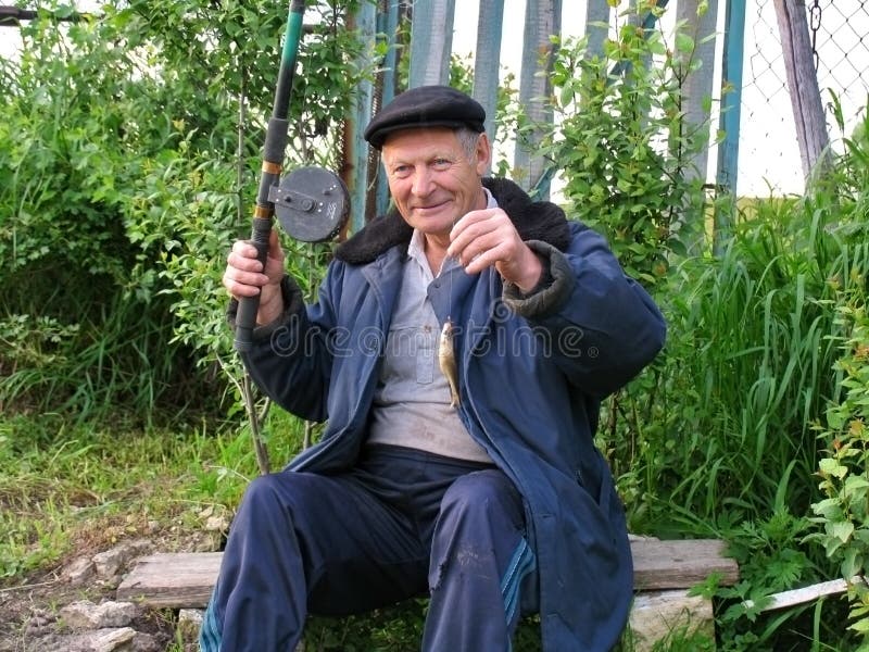 Old rural man brags a caught small fish stock photos