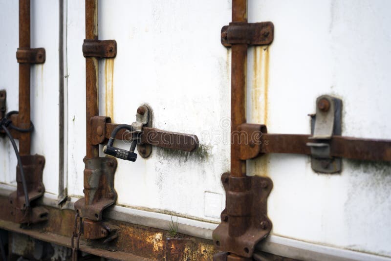 Old rusted door closing mechanism of the semi trailer with digit stock photo