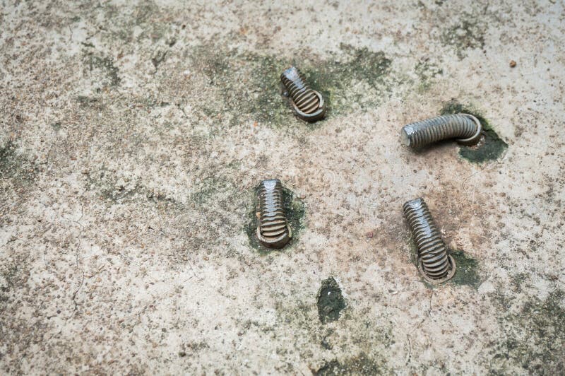 Old Sleeve Anchor Bolt or Expansion Bolt buried in Concrete Side. Walks stock image