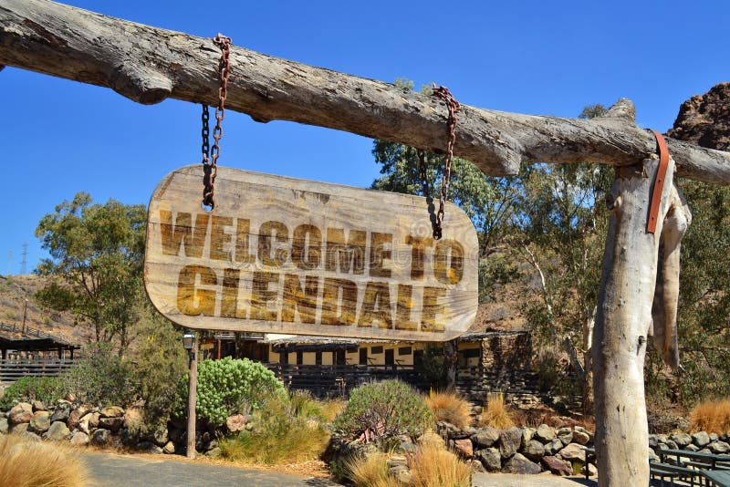 Old wood signboard with text welcome to Glendale. hanging on a branch. Old vintage wood signboard with text welcome to Glendale. hanging on a branch stock photo