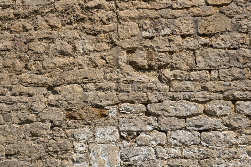 Old weathered exterior stone wall construction full frame background. An old weathered stone wall needs repairs. Construction full frame texture background stock images