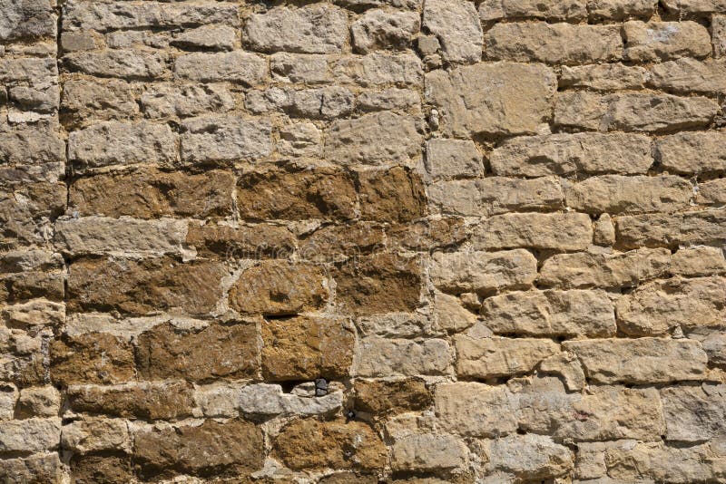 Old weathered exterior stone wall construction full frame background. An old weathered stone wall needs repairs. Construction full frame texture background stock photo