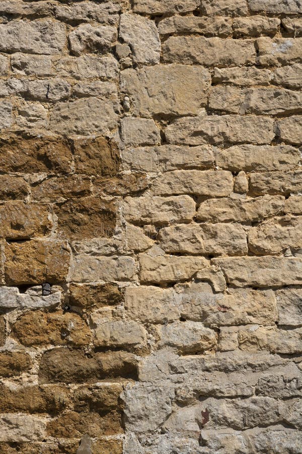 Old weathered exterior stone wall construction full frame background. An old weathered stone wall needs repairs. Construction full frame texture background royalty free stock images