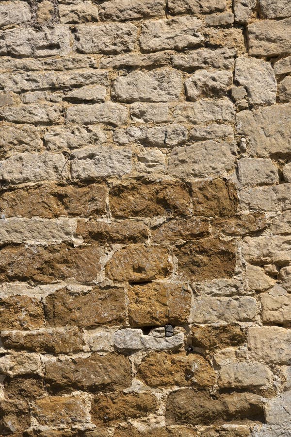 Old weathered exterior stone wall construction full frame background. An old weathered stone wall needs repairs. Construction full frame texture background stock photography