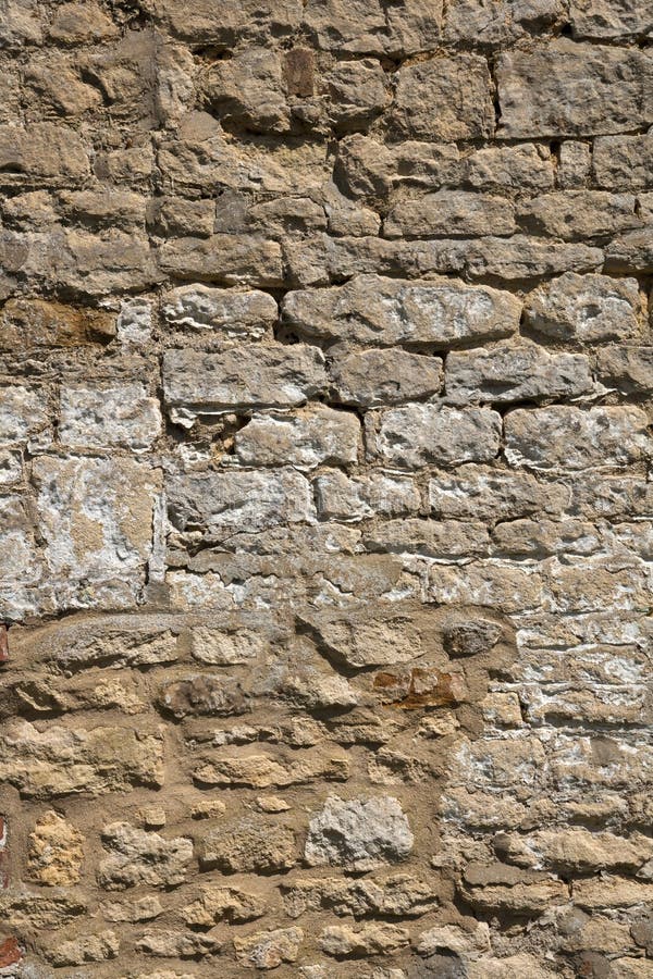 Old weathered exterior stone wall construction full frame background. An old weathered stone wall needs repairs. Construction full frame texture background royalty free stock image