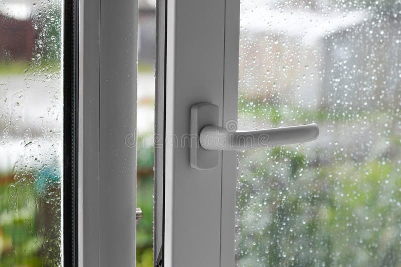 Open white plastic window. In the rainy weather. Closeup royalty free stock image