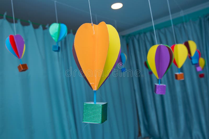 Origami made colorful air balloon cloud. Beautiful colored paper lanterns hanging on the ceiling as air balloons. Hanging from above Colorful paper balloon with royalty free stock photos