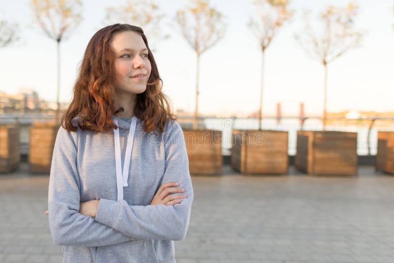 Outdoor portrait of beautiful smiling teenager girl 14, 15 years old. Golden hour stock photography