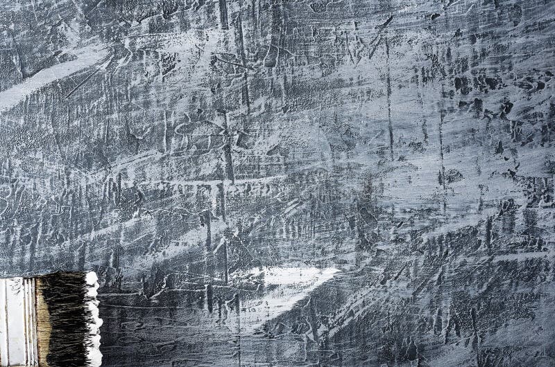Part of the brush in black and white paint on the background of a concrete painted gray background at the bottom left.  royalty free stock image