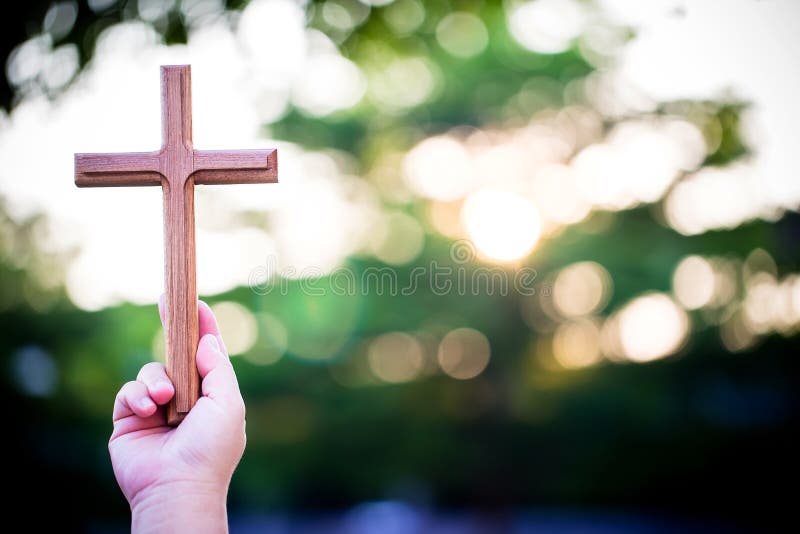 Person palm hands to hold holy cross, crucifix to worship. stock photography