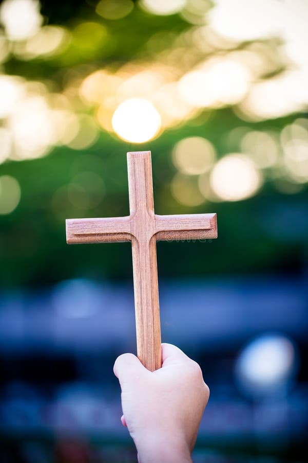 Person palm hands to hold holy cross, crucifix to worship. royalty free stock image