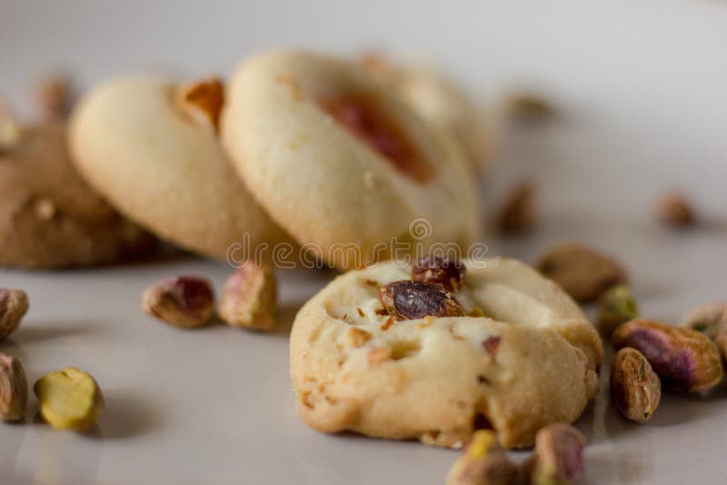 Pistachio butter cookies oven fresh,with pistachios sprinkled in  on top of them isolated in a white background. stock photography