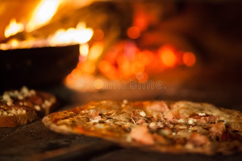 Pizza in old stove. Fire temperature hot stock image