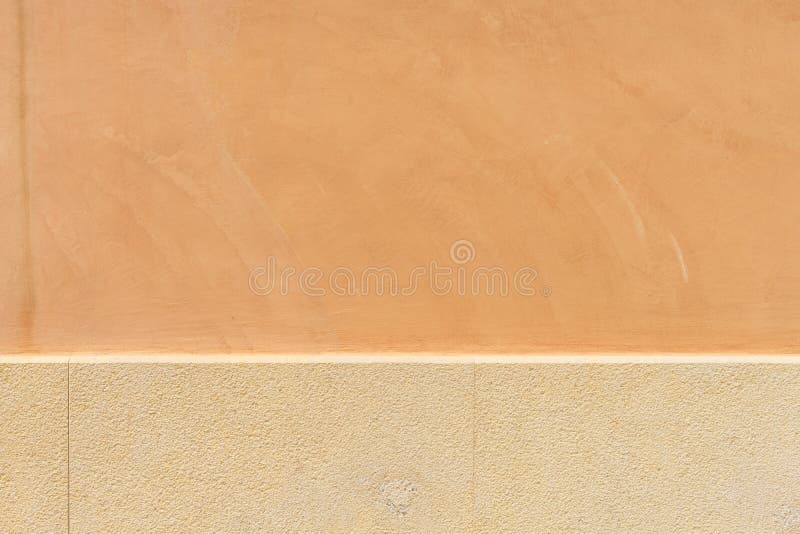 Plastered facade earth-colored. With tiles at the socle as backdrop stock image