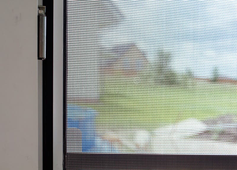Plastic window with mosquito net. Indoor detail closeup stock photo