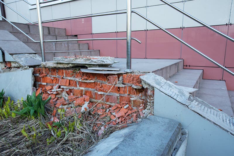 Crumbling brick porch needs repair. Poorly made repairs in the entrance, the entrance to the porch of the building and the stairs are destroyed, ceramic tiles royalty free stock image