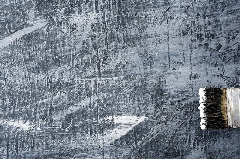 Portion of the brush in black and white paint on the background of a concrete painted gray background on the right bottom.  stock images