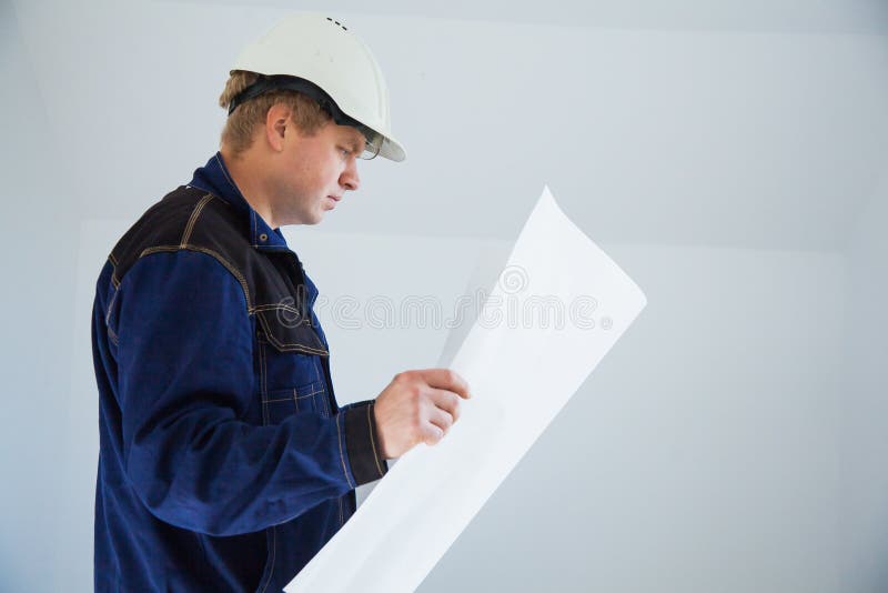 Portrait of an architect builder studying layout plan of the rooms royalty free stock images