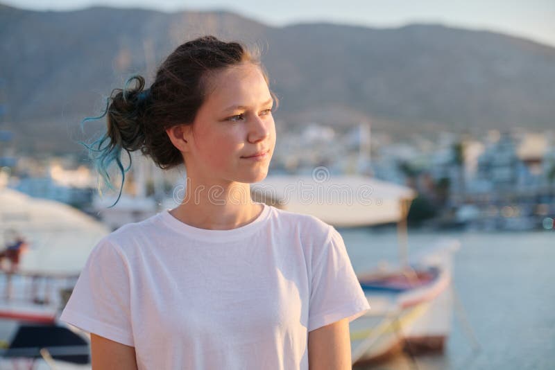 Portrait of teenage girl 15 years old, happy smiling teenager. Summer sunset sea harbor with yachts background. Vacation, adolescence, travel concept royalty free stock photo